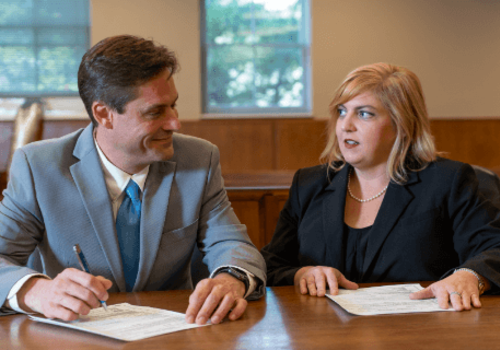 Paul Seckel and Emily Jolley having a discussion at their desk.