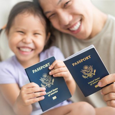 Father and daughter smiling and holding passports