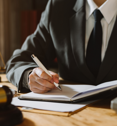 An attorney writing notes at his desk.