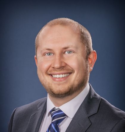 Kevin Price in a suit smiling