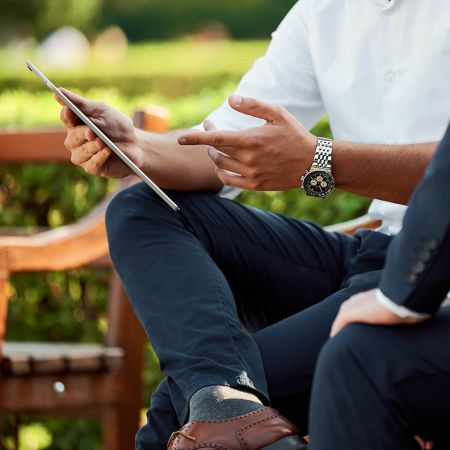 Two businessmen having a discussion on a park bench