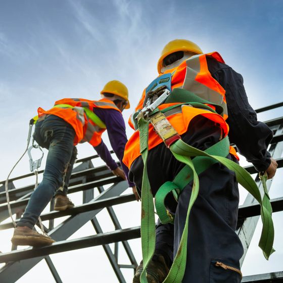 Two construction workers with safety equipment on.
