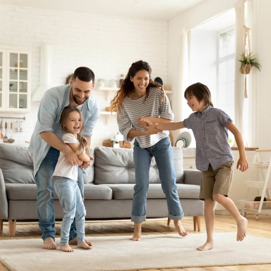 Parents playing with their children in their living room.