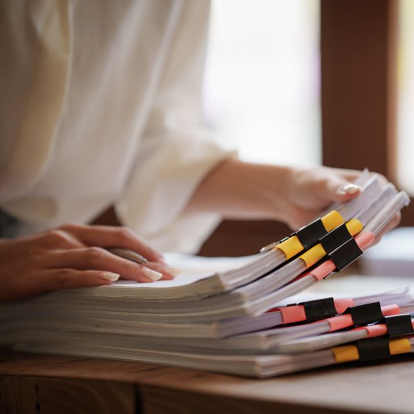A woman sorting stacks of paper