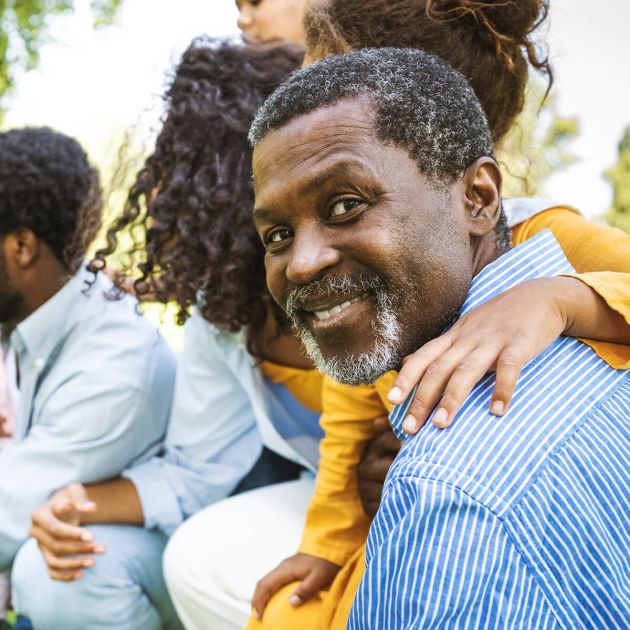 A black grandpa surrounded by his children