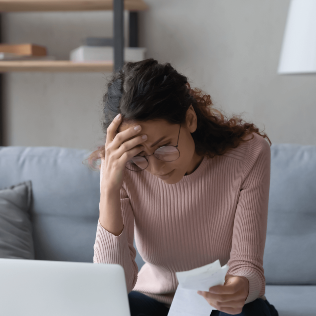 Unhappy young woman in glasses feeling stressed calculating monthly expenses at home