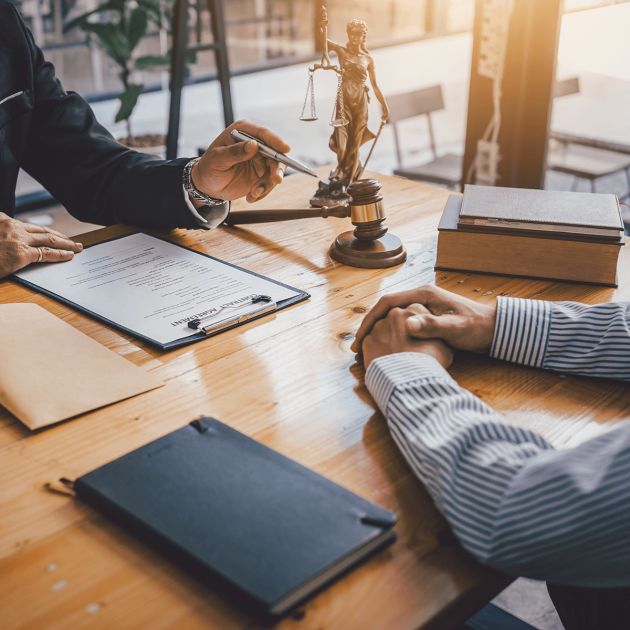 An attorney talking with a client at a desk.