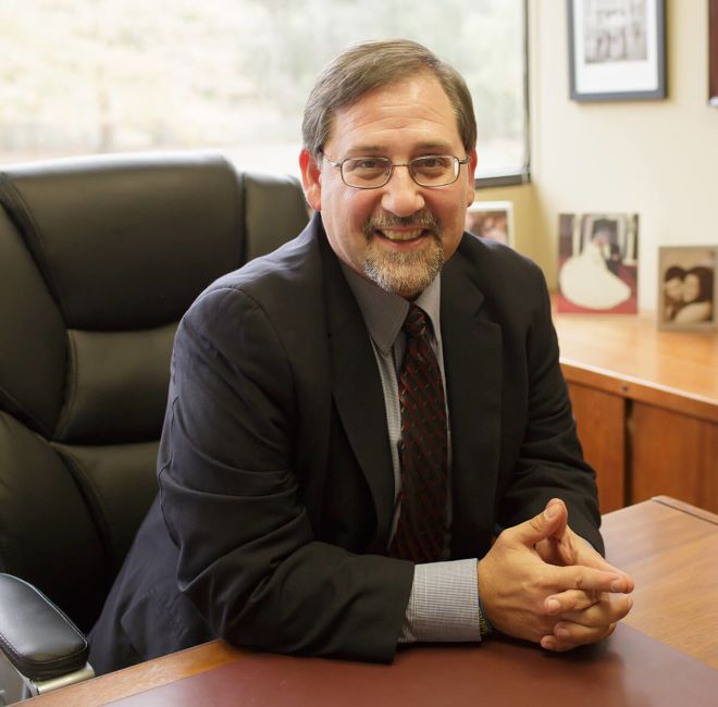 Nachbar sitting at his desk, hands folded