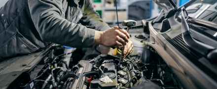 A mechanic inspecting a car.