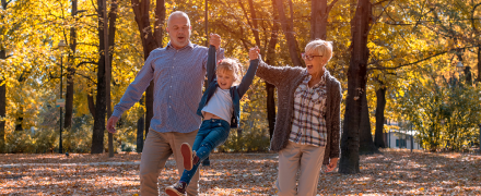 Grandparents swinging their grandchild with their arms.