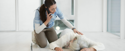 Accident, phone call and nurse with old woman on floor for medical, injury and elderly care.