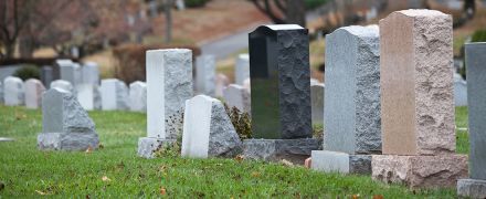 A cemetery with several head stones.