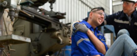 A man holding injured shoulder at work.