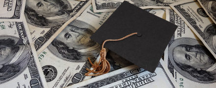 Graduation cap on a pile of money.