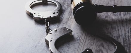 Handcuffs next to a gavel.