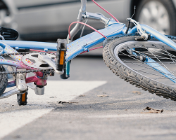 Close-up of a bicycle on an empty road crossing with cars in the background