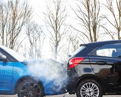 Man getting out of car to inspect damage after car crash