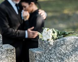 Man and woman grieving at the grave of wrongful death victim