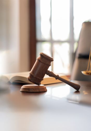 judge gavel, law books and scales of justice on desk in lawyer office.