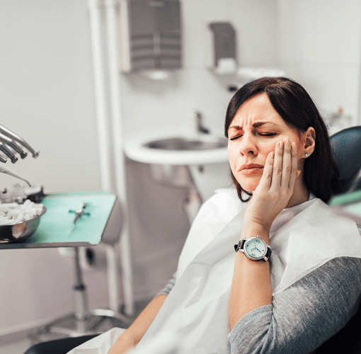 a woman having tooth pain in dental chair