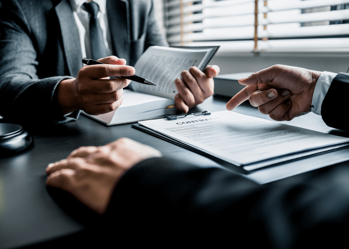 Close up of businessmen or lawyers discussing contract or business agreement at law firm office