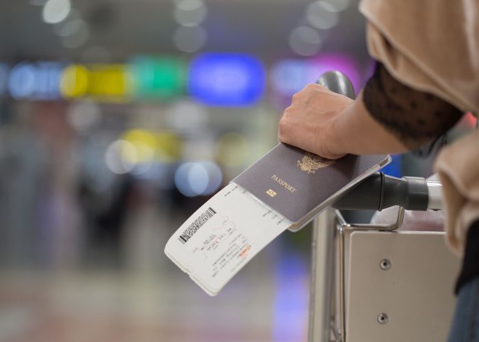 Closeup of girl holding passports and boarding pass at airport