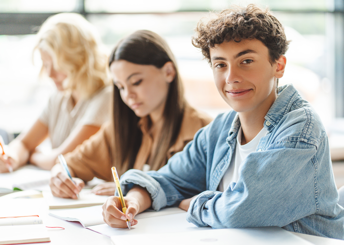 A teenage boy studying with his classmates.