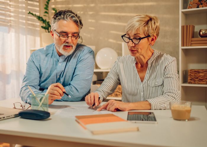 An older couple sitting down discussing paperwork together.