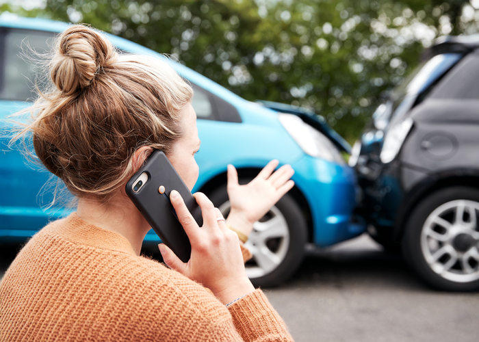 A woman calling someone after being involved in a car accident