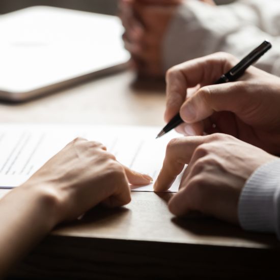 Solicitor pointing at contract showing client where to write signature