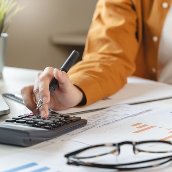 person using calculator calculating tax refund on the table