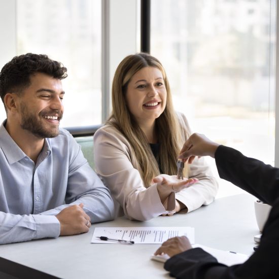Smiling millennial couple finalize deal with real estate agent professional or sales manager