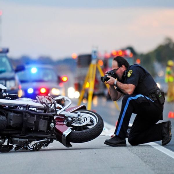 Cop taking a photo of a wrecked motorcycle