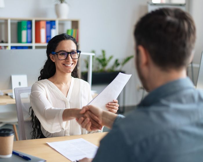 Coworkers shaking hands during a meeting.