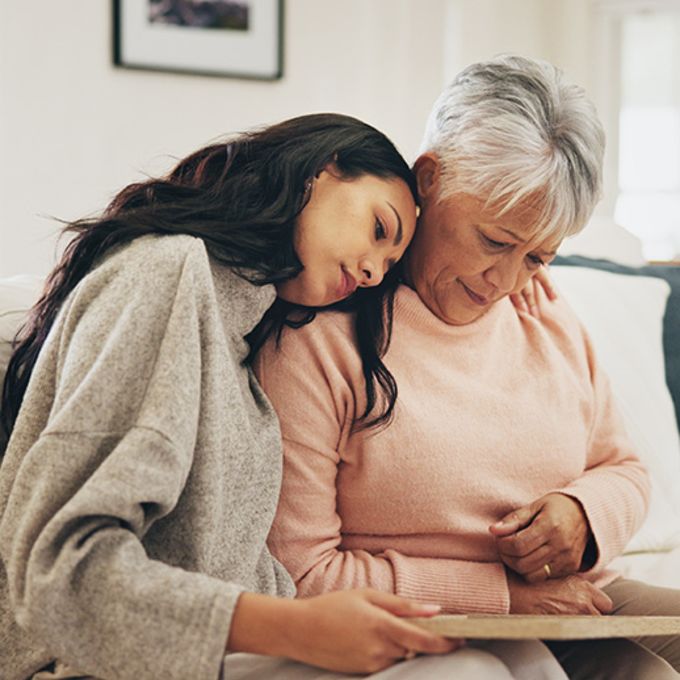 Women, senior mother and sad with photo frame, hug and empathy for grief, memory and love in lounge.
