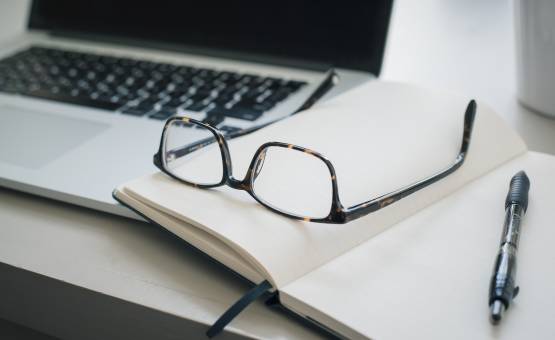office supplies and glasses laying on desk