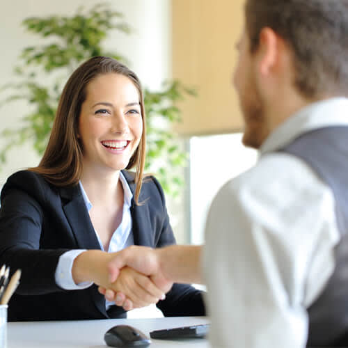 Woman smiling and shaking hands with a man