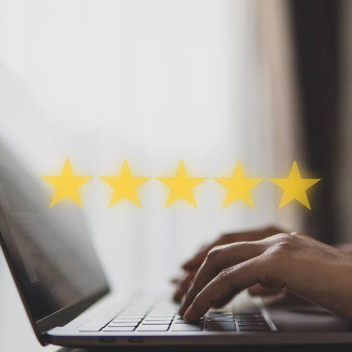 Person typing on a computer with 5 stars graphics floating above