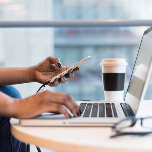 Woman working on a phone and computer