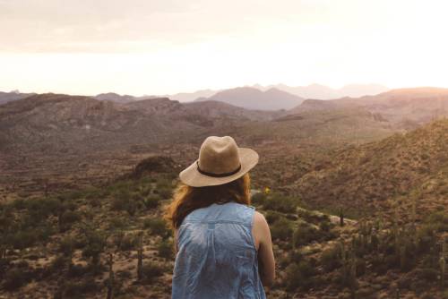 Woman watching a sunset in the mountains of a desert