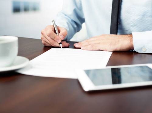 man sitting at a desk writing