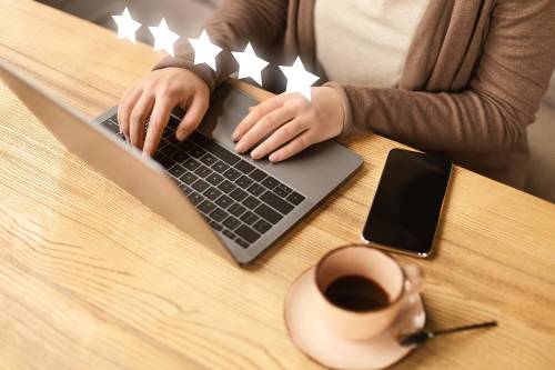 Woman typing at computer with 5 stars