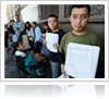 People standing in a row holding up papers