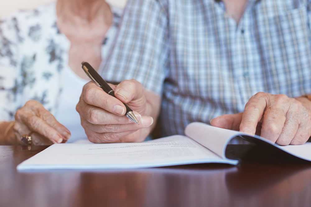 Older couple signing a will together