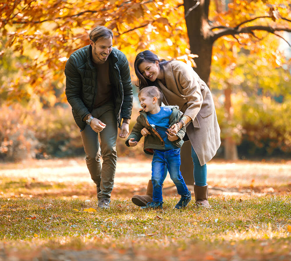 Family playing together in park during autumn