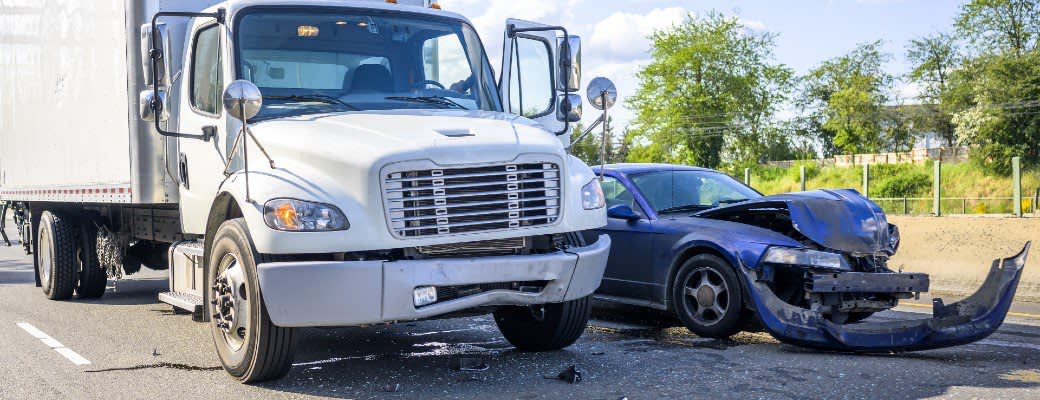 truck next to car with hood and bumper damage
