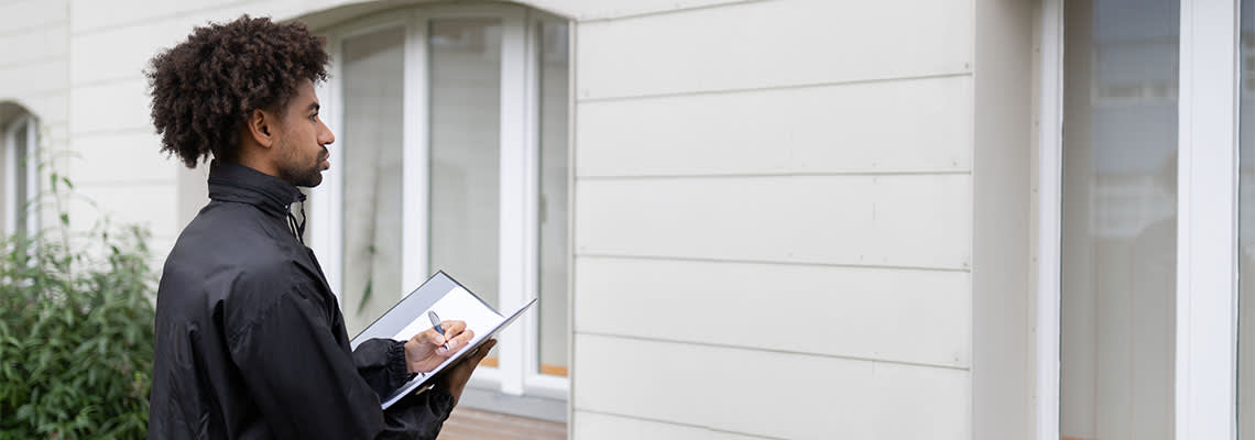 Person holding clipboard looking at building