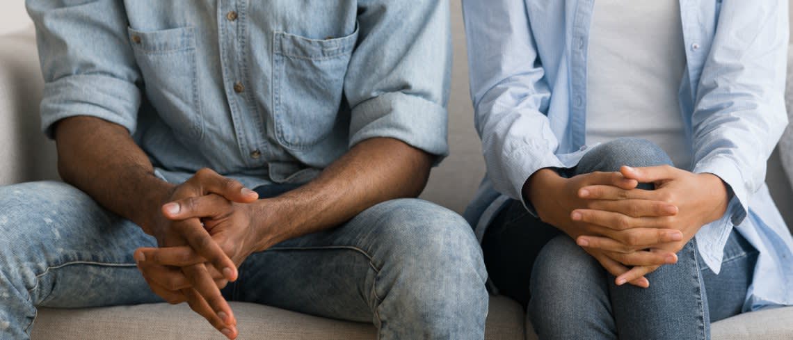 Couple sitting next to each other in therapy with closed