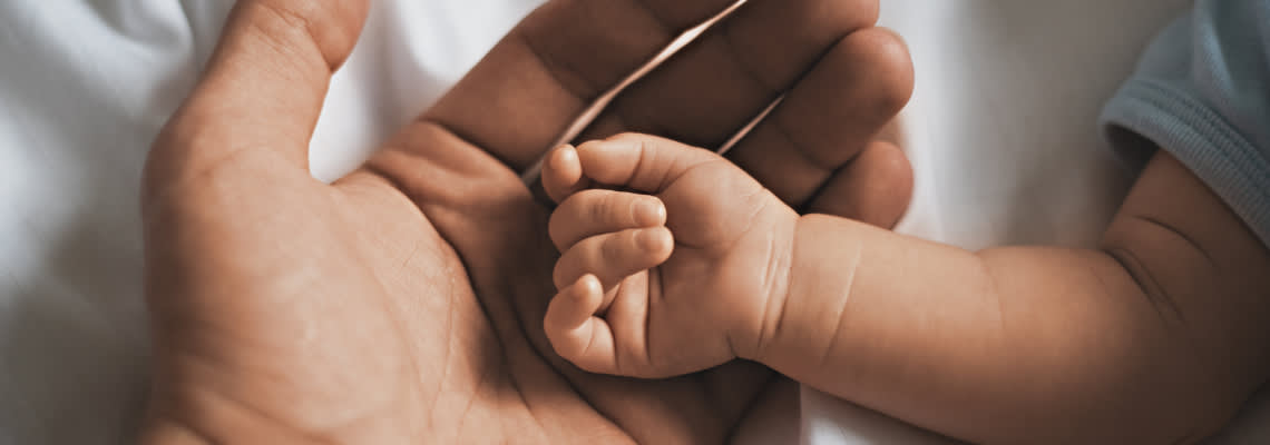 Small hands of baby in father's hand