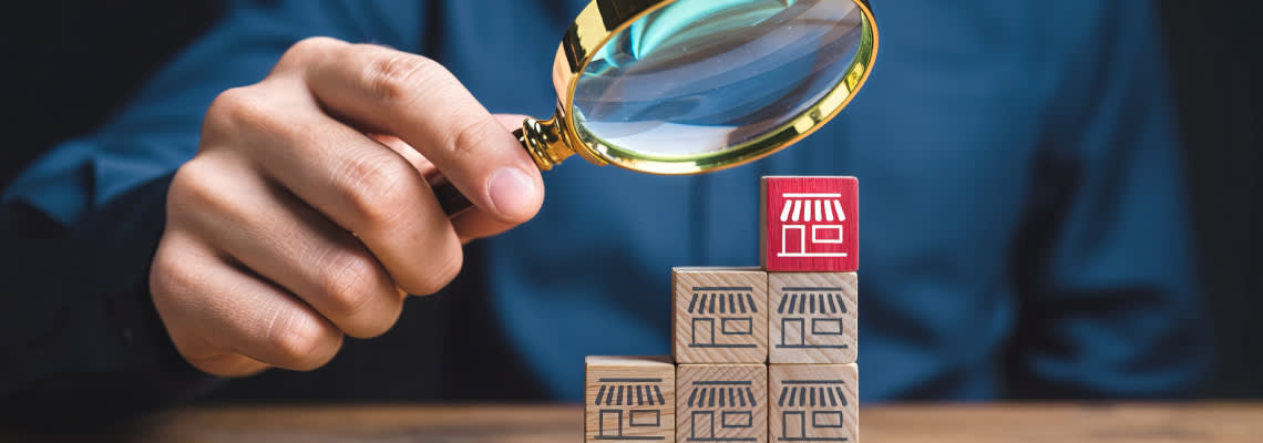 Magnifying glass over stacked blocks representing franchise business